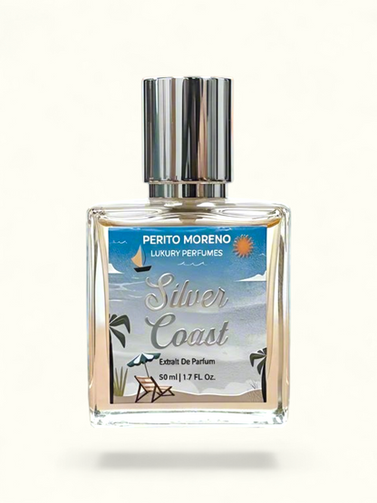 Perfume bottle labeled 'Silver Coast' by Perito Moreno on a beach with a sunset in the background
