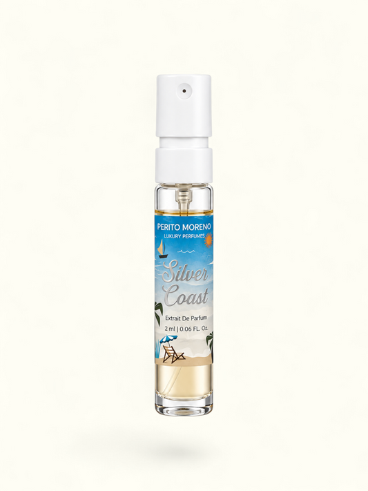 A 2ml perfume atomizer bottle with a white spray cap and a tropical beach-themed label reading 'Perto Moreno Silver Coast Extrait De Parfum'. The bottle is filled with a light golden liquid and set against a plain white background.