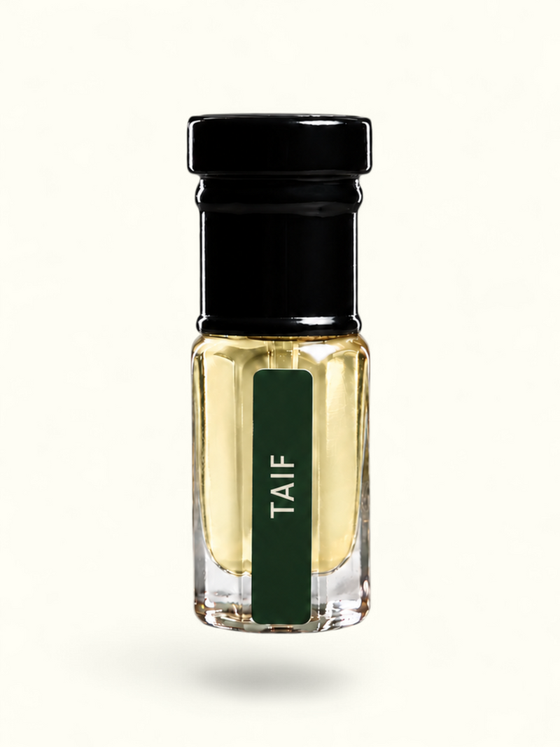 A small clear glass bottle with pale yellow liquid, a black cap, and a dark green vertical label reading 'TAIF' in white text, centered on a plain white background.