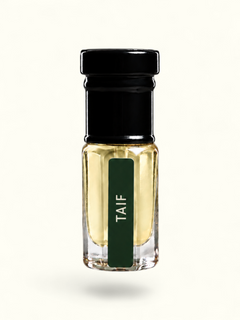 A small clear glass bottle with pale yellow liquid, a black cap, and a dark green vertical label reading 'TAIF' in white text, centered on a plain white background.