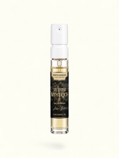 A 2 ml clear glass perfume spray bottle with a white atomizer cap, containing light amber liquid. The bottle features a black label with gold lettering that reads 'PERTO MORENO CAYE PERFUMES' and 'VETIVER MYSTIQUE'.