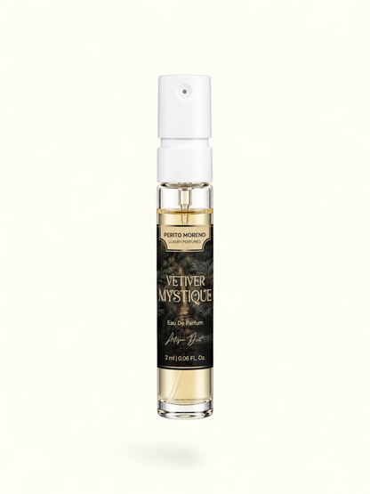 A 2 ml clear glass perfume spray bottle with a white atomizer cap, containing light amber liquid. The bottle features a black label with gold lettering that reads 'PERTO MORENO CAYE PERFUMES' and 'VETIVER MYSTIQUE'.
