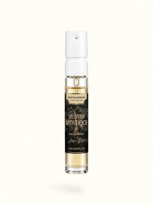 A 2 ml clear glass perfume spray bottle with a white atomizer cap, containing light amber liquid. The bottle features a black label with gold lettering that reads 'PERTO MORENO CAYE PERFUMES' and 'VETIVER MYSTIQUE'.