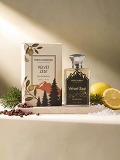 PERFUME BAY Velvet Zest eau de parfum bottle and box with lemon, pine needles, and peppercorns on a stone surface.