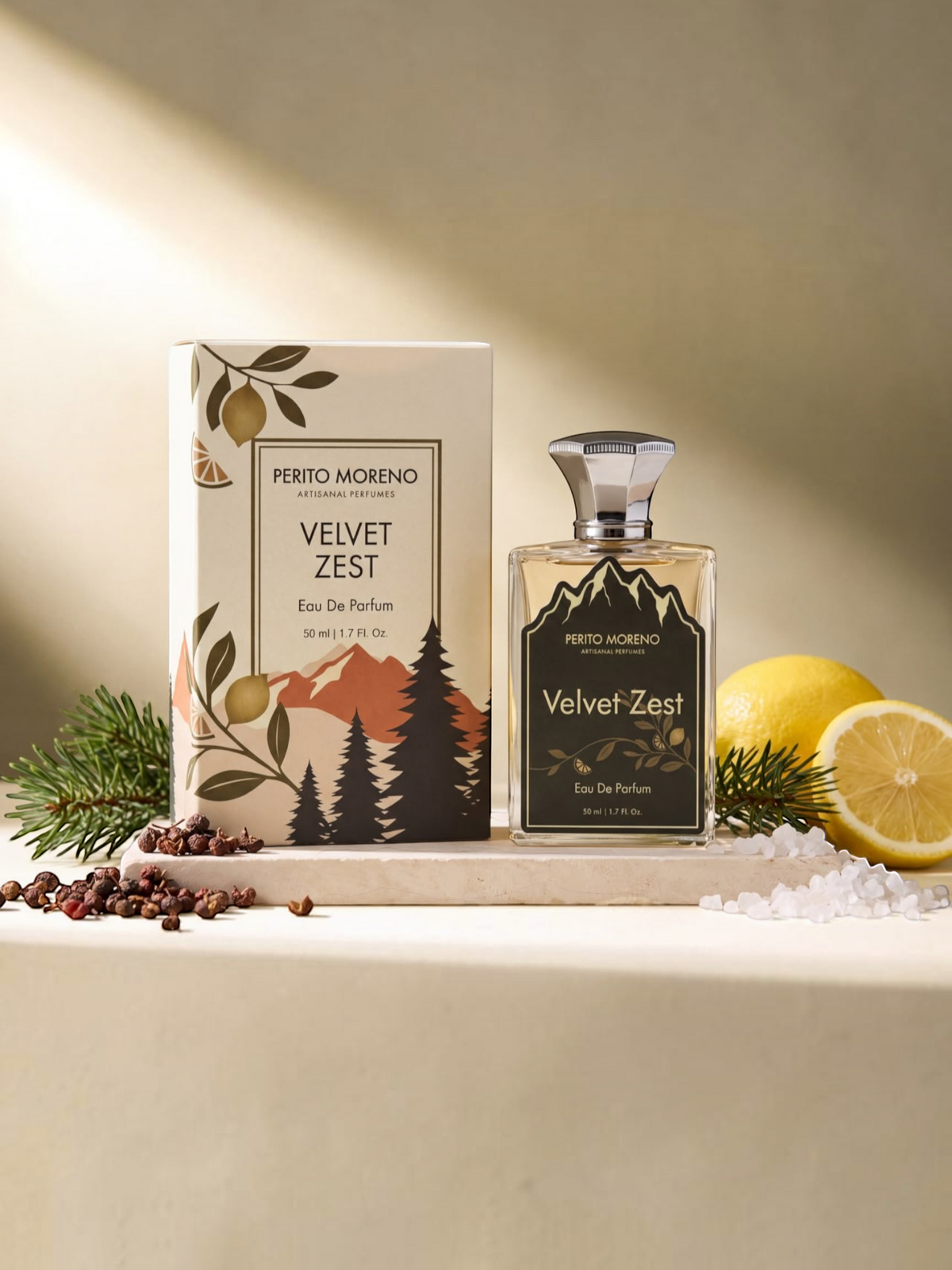 PERFUME BAY Velvet Zest eau de parfum bottle and box with lemon, pine needles, and peppercorns on a stone surface.
